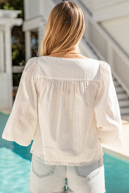 Person wearing a light-colored blouse by a poolside
