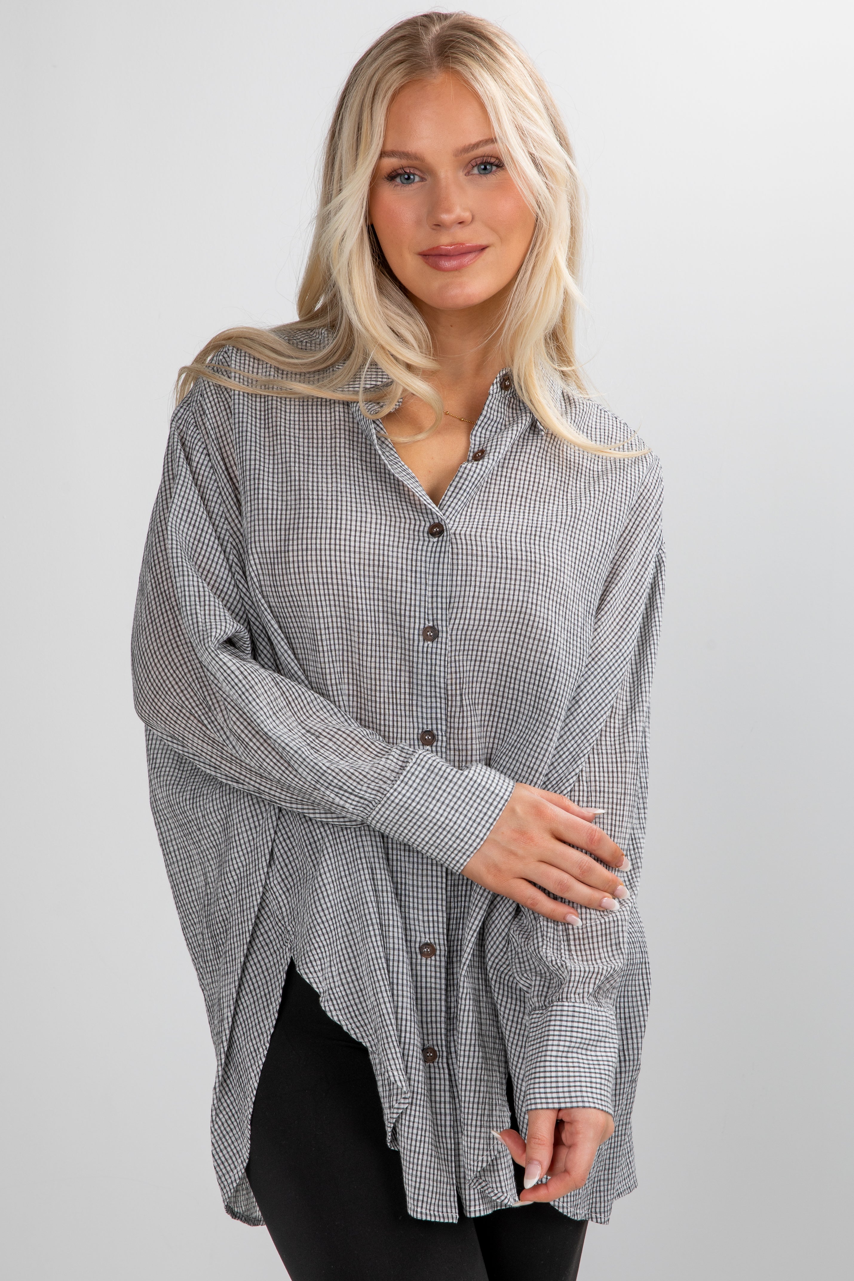 Woman wearing a checkered shirt on a plain background