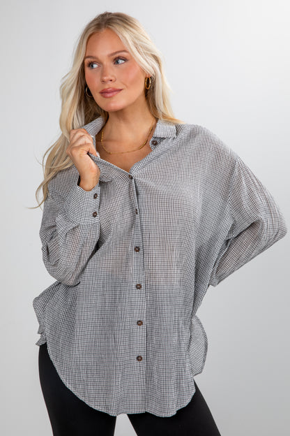 Woman wearing a checkered shirt with a plain background
