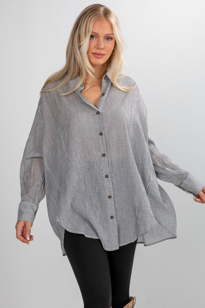 Woman wearing a checkered shirt with a plain background