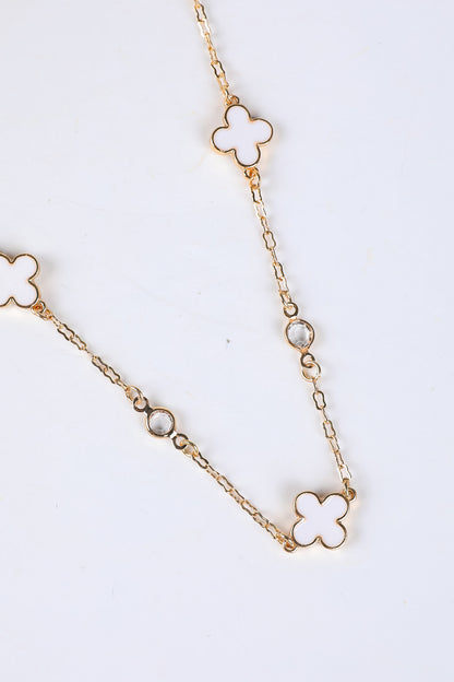 Gold chain necklace with clover-shaped pendants on a white background