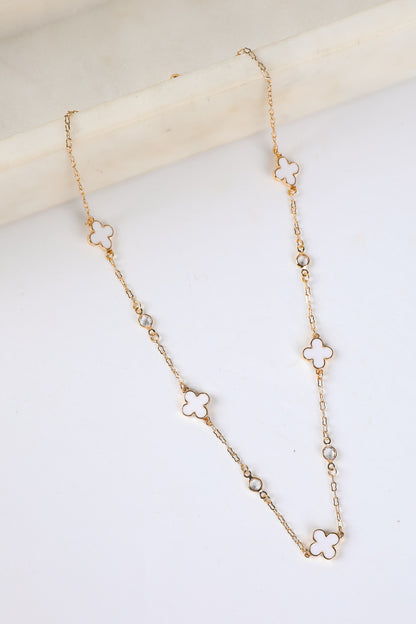 Gold necklace with clover-shaped links on a light background