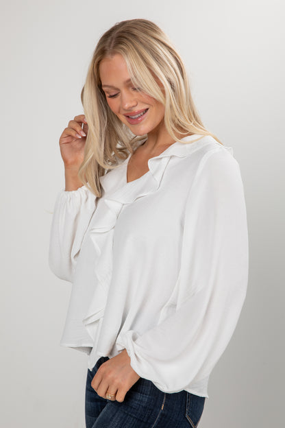 Woman wearing a white blouse against a plain background