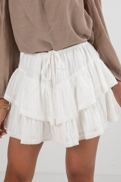 White ruffled skirt worn by a person on a white background