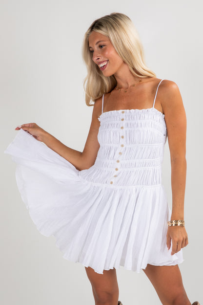 Woman wearing a white dress with a plain background