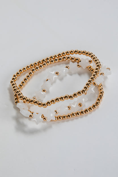 Gold chain bracelet with white stones on a light gray background