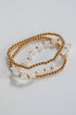 Gold chain bracelet with white stones on a light gray background