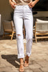 Person wearing white jeans with slight distressing, standing on a patio.