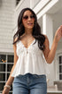 Woman wearing a white top and blue jeans outdoors