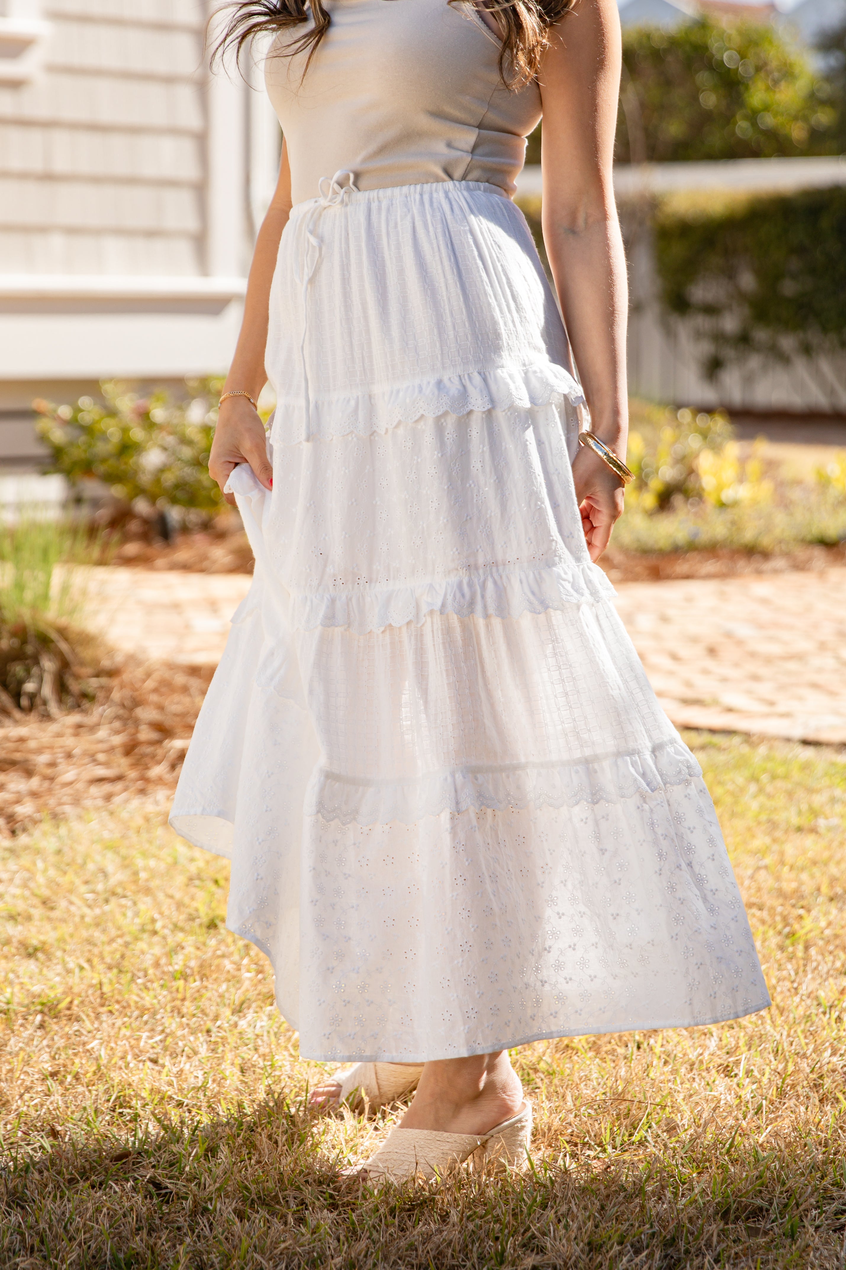 Person wearing a white dress standing outdoors on grass