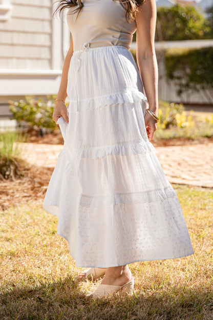 Person wearing a white dress standing outdoors on grass