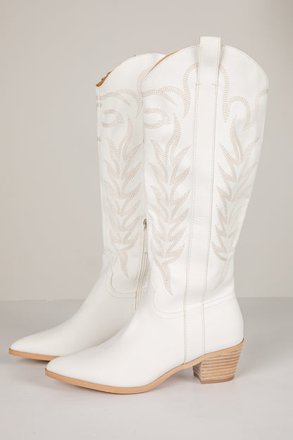 White cowboy boots with braided design on a light gray background