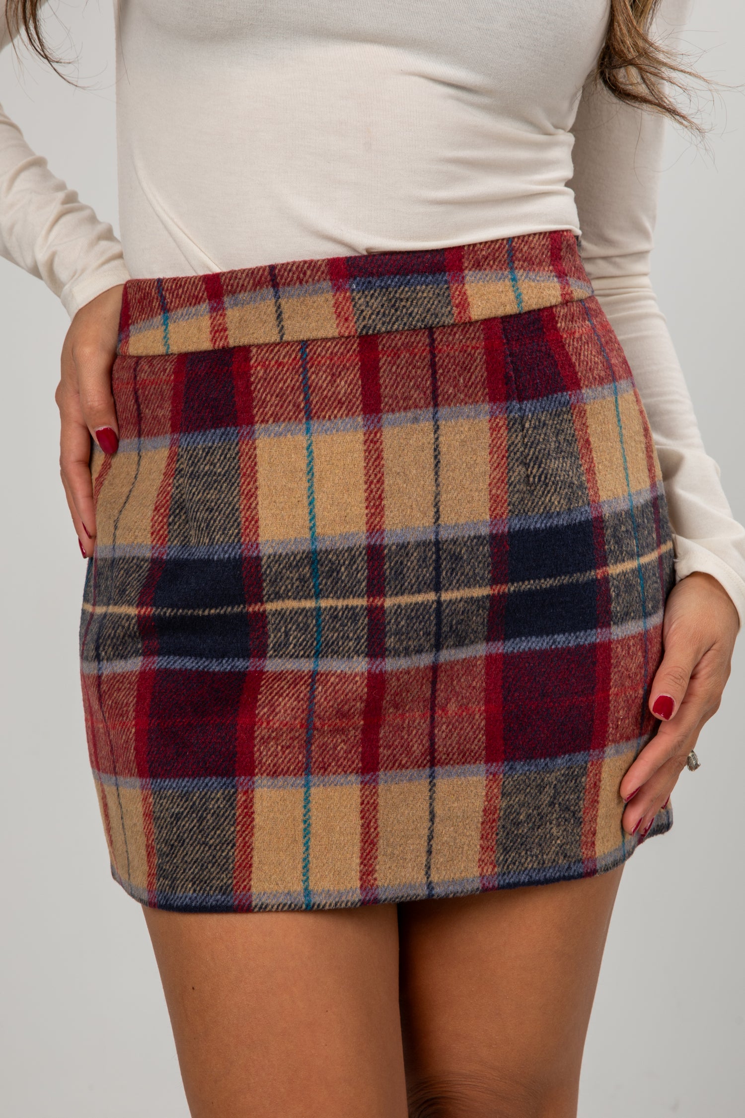 Plaid skirt worn by a person on a plain background