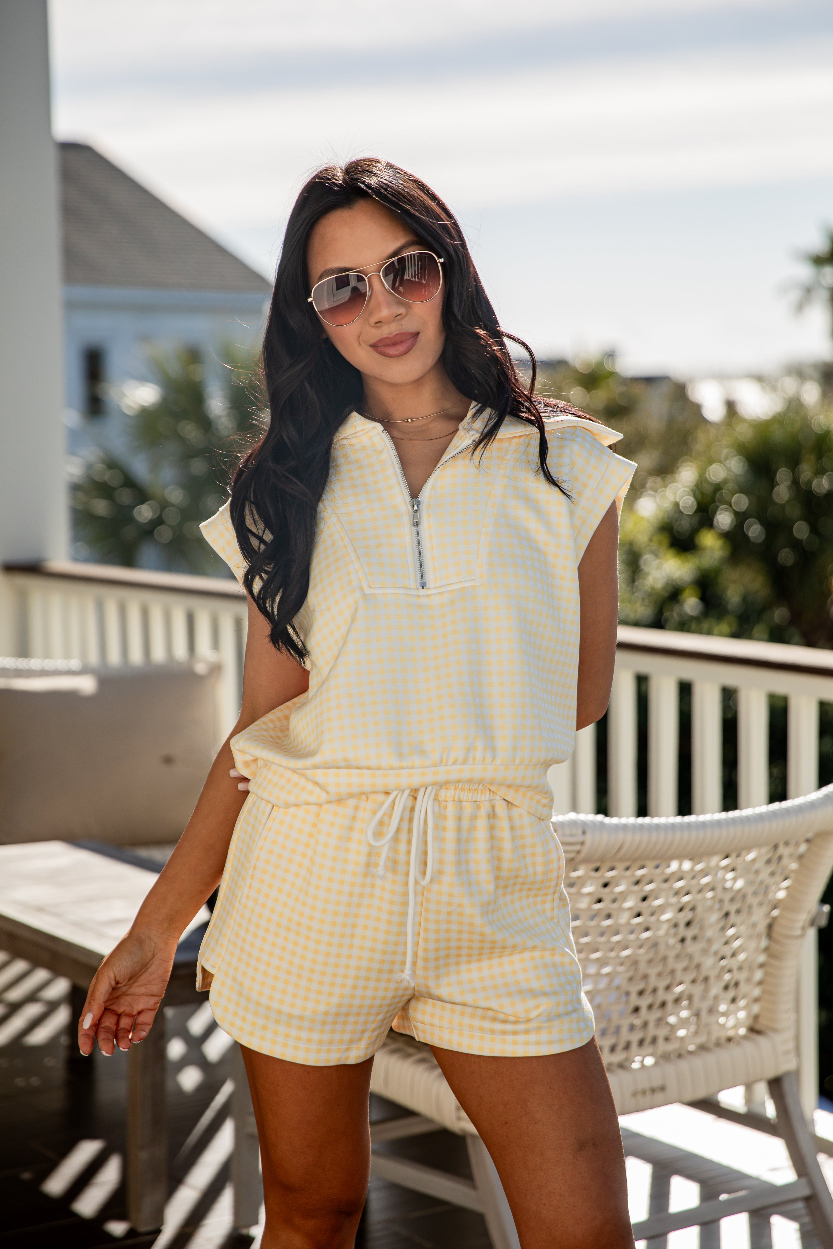 woman wearing yellow gingham drawstring active shorts with matching top