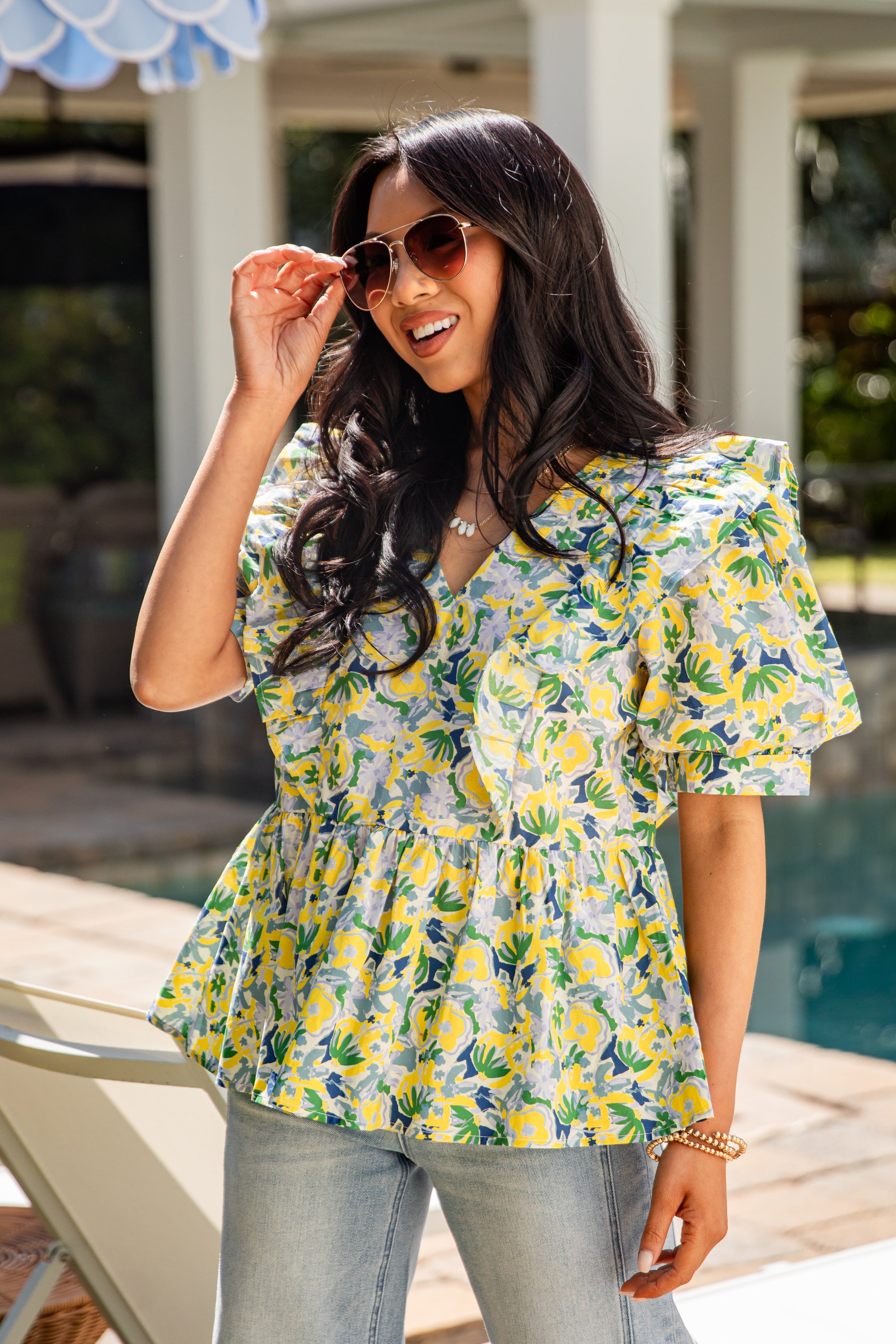 Woman wearing a floral top by a poolside