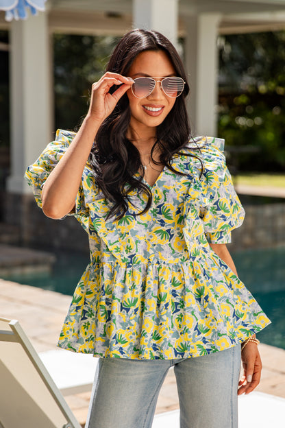 Woman wearing a floral blouse by a poolside