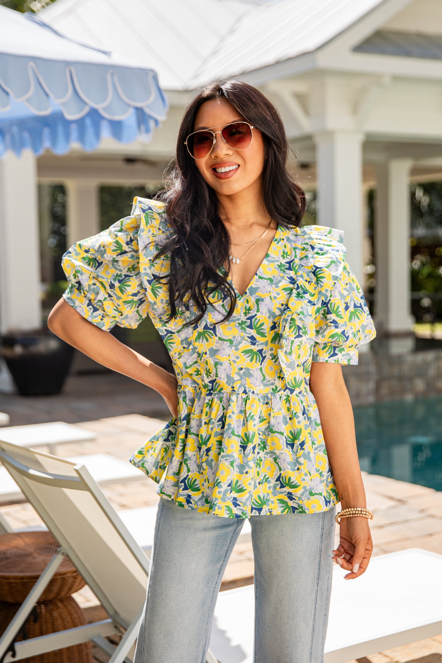 Woman wearing a floral blouse by a poolside