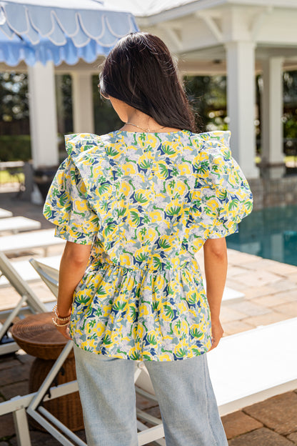 Woman wearing a floral blouse by a poolside