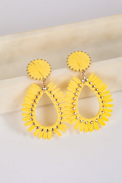 Yellow hoop earrings with circular details on a light background