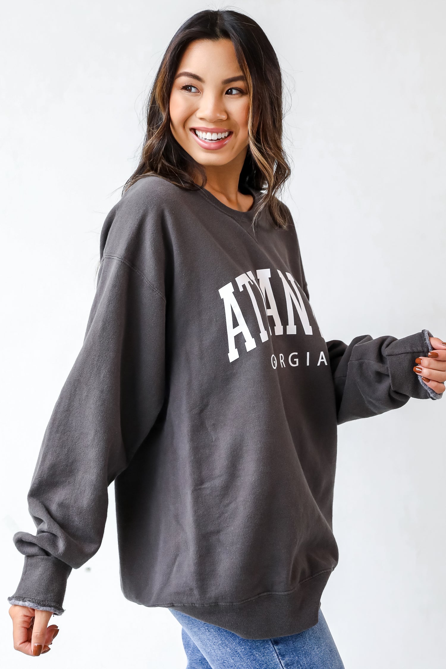 This comfy sweatshirt is designed with a soft and stretchy knit with a fleece interior. It features a crew neckline, long sleeves, a relaxed fit, and the words &quot;Atlanta Georgia&quot; on the front.