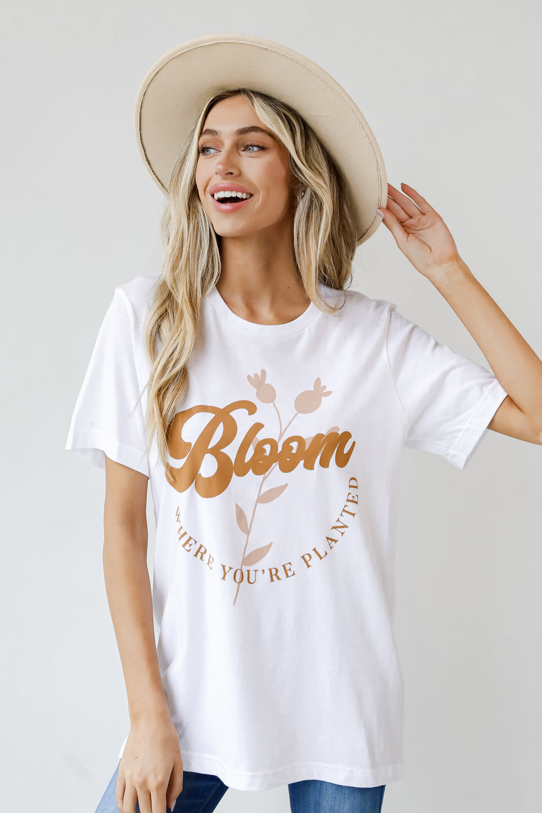 This comfy tee is designed with a soft and stretchy knit. It features a crew neckline, short sleeves, a relaxed fit, and the words "Bloom Where You&