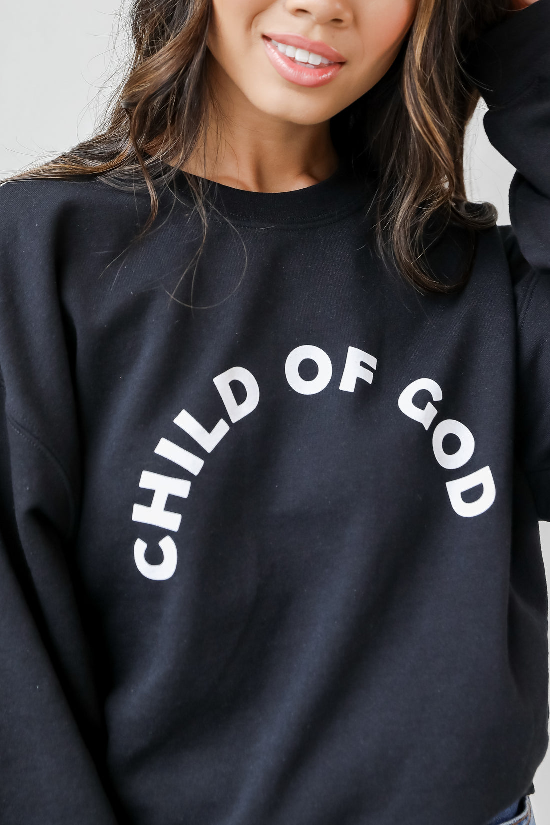 This comfy sweatshirt is designed with a soft and stretchy knit with a fleece interior. It features a crew neckline, long sleeves, a relaxed fit, and the words &quot;Child Of God&quot; on the front. 