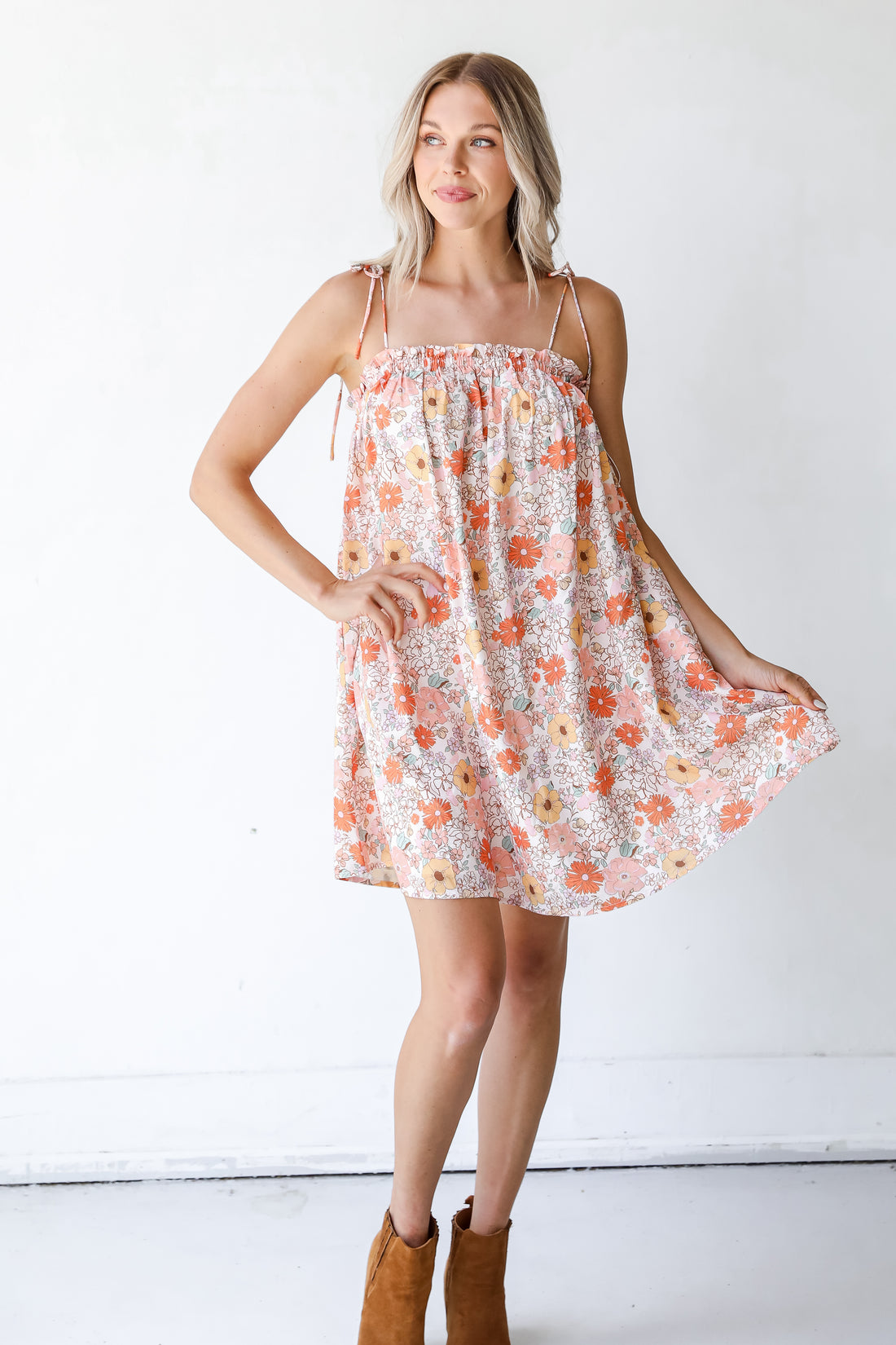 model wearing a Floral Mini Dress with tan booties
