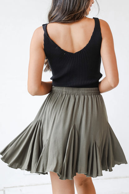This cute skirt is designed with a lightweight woven knit. It features an elastic waistband with a functional drawstring and a flowy fit that ends at a mini length.