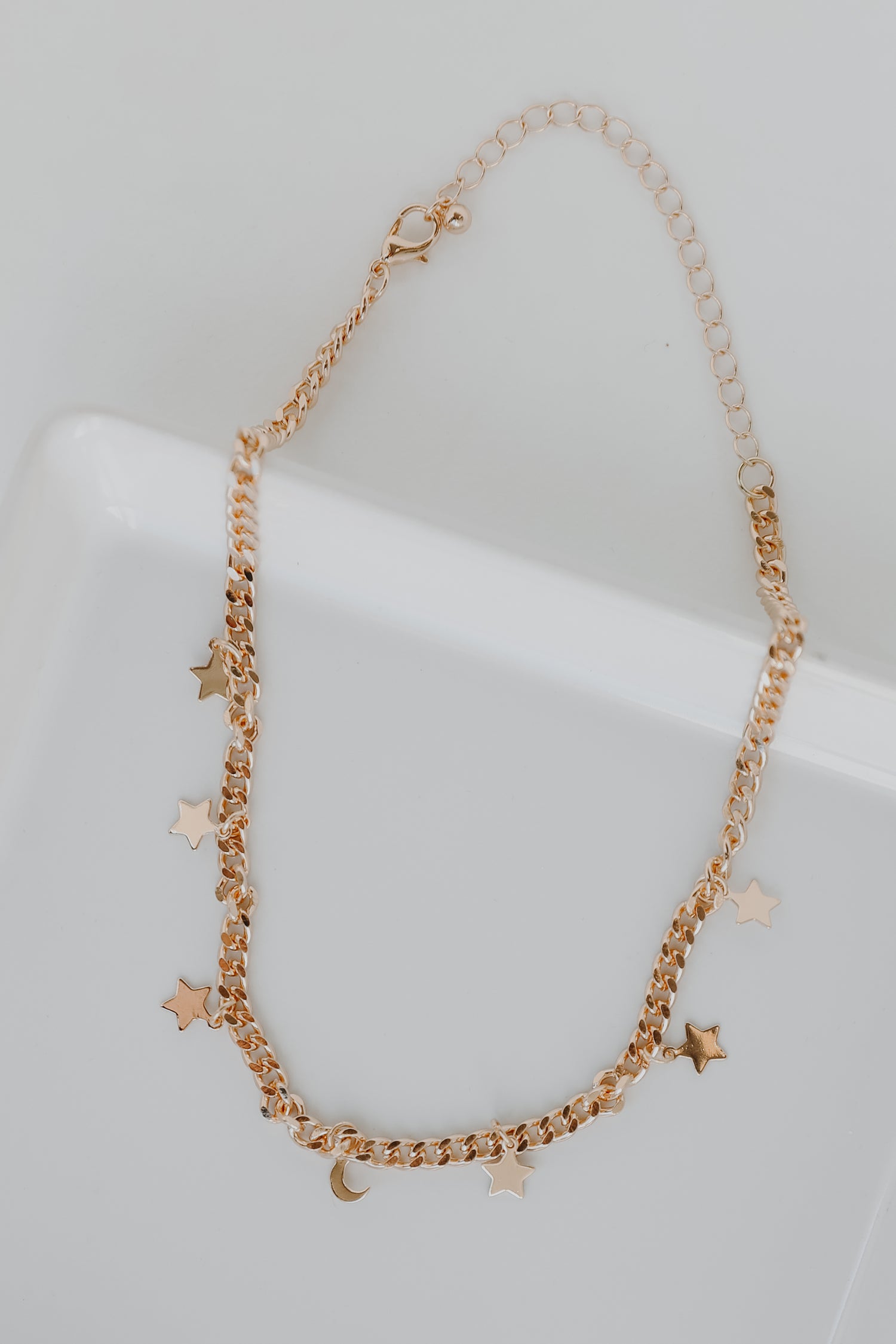 Gold Star + Moon Necklace flat lay