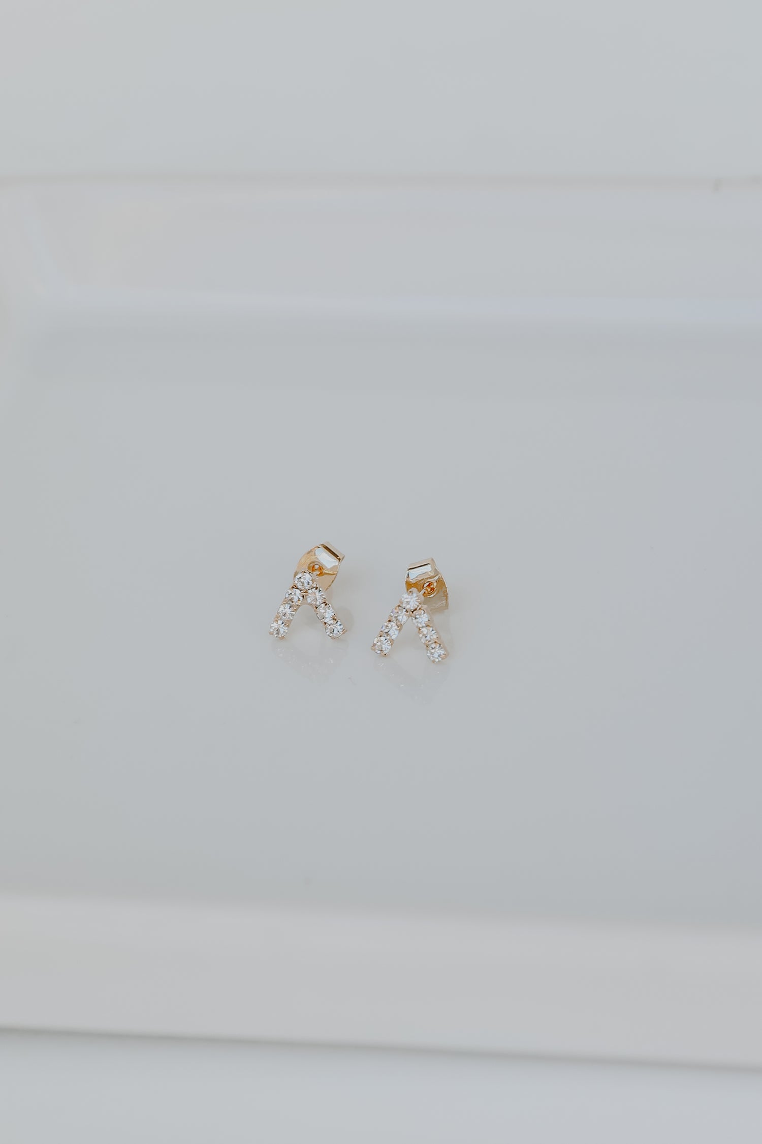 Gold Rhinestone V Stud Earrings flat lay